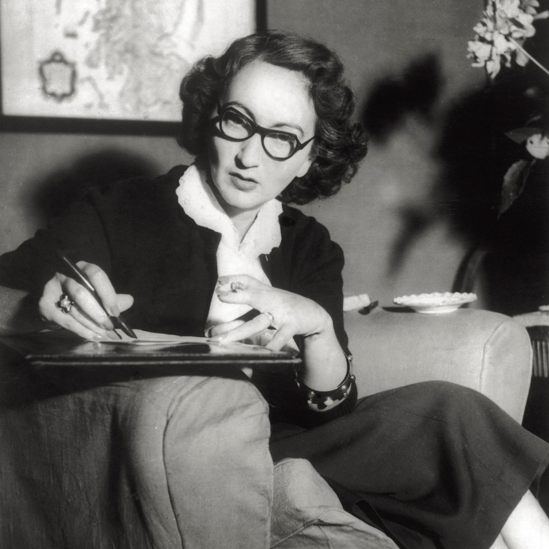 The writer Alba de Cspedes photographed while taking notes sitting in an armchair in the nineteenfifties.